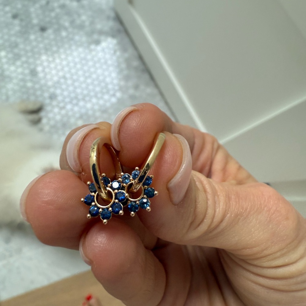 Gold hoops with sapphire flower charms.